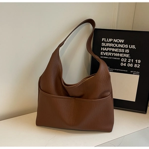 Detailed view of the dark brown lychee pattern leather and front pocket on the hobo bag