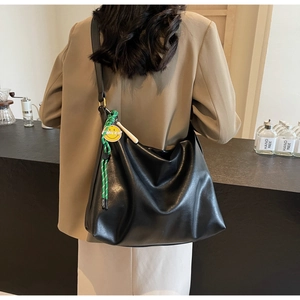 Détail du sac hobo noir avec cordelette verte et pendentif smiley jaune stylé