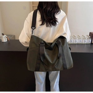 Man wearing military green waterproof travel bag with adjustable strap in modern bar setting