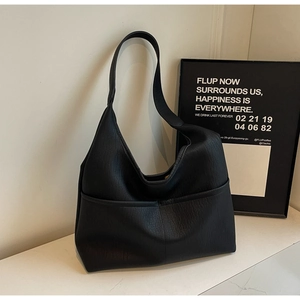 Close-up of minimalist black hobo bag showing high-quality pebbled leather texture