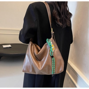 Détail du sac hobo marron avec corde tressée verte et pendentif smiley jaune vif