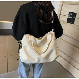 Detail of the large capacity cream tote bag showing texture and adjustable strap
