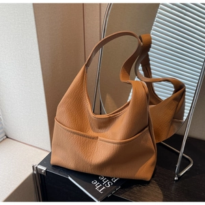 Macro detail of brown pebble grain leather tote with symmetrical front pockets