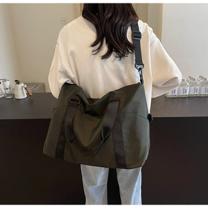 Detailed view of olive green travel bag with black straps and waterproof fabric