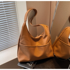 Macro detail of vintage brown lychee grain leather tote bag with functional double pockets