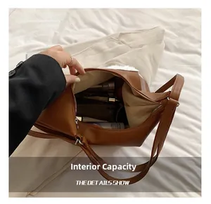 Macro view of the large internal capacity showing phone and skincare items in brown bag