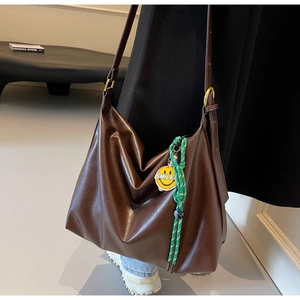 Détail du sac cabas marron café avec boucle en métal et pendentif smiley jaune