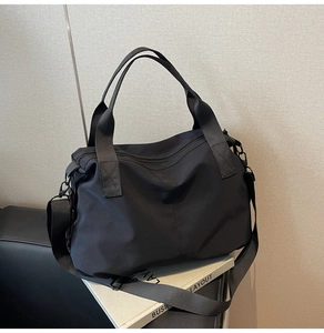 Detail of black nylon tote bag with reinforced handles and adjustable shoulder strap