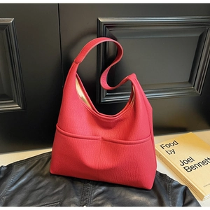Close-up of red lychee textured leather tote bag with functional front pockets