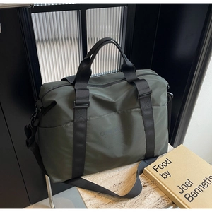 Detailed view of deep green travel duffle bag with handles and detachable shoulder strap