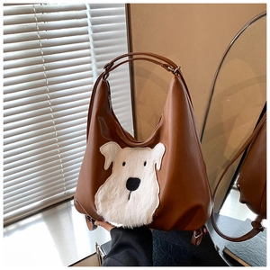 Macro view of vintage brown PU leather bag with white plush puppy patch and strap detail
