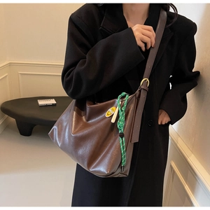 Détail du grand sac cabas marron foncé avec cordon vert et pendentif smiley sur mannequin