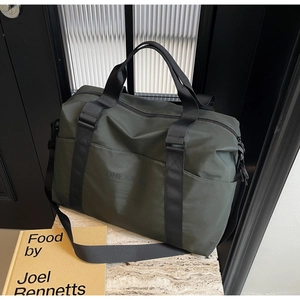Macro view of dark green nylon travel bag on stone base with black carry straps