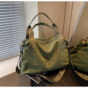 Macro shot of an olive green canvas tote bag with reinforced handles and durable metal buckles