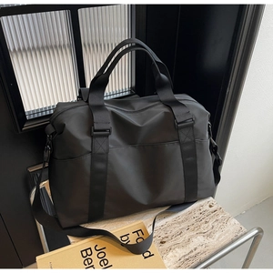 Detail of black sports duffel bag with shoulder strap on stone countertop