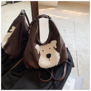 Detail of saddle-shaped brown PU leather handbag with white plush schnauzer design