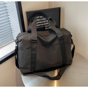 Detail of black large capacity travel bag on metal stand with adjustable strap and handles