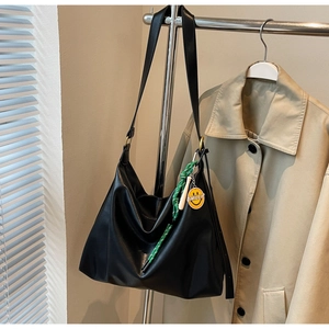 Détail du grand sac hobo noir avec corde tressée verte et breloque smiley jaune vif