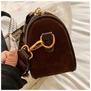 Detail of coffee Boston bag featuring suede texture and bohemian wide strap