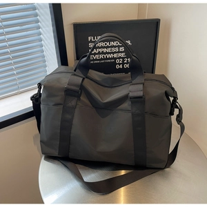 Detail of waterproof black travel bag showing large front pocket and Camelloco logo