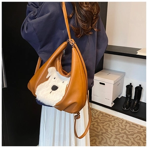 Close-up of brown faux leather shoulder bag with a white plush dog head applique