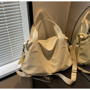 Close-up of the cream large-capacity tote bag with durable nylon and black metal zippers