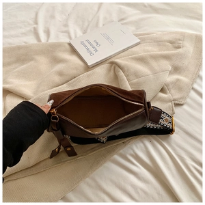 Detail of dark brown cylinder pillow bag with suede texture and geometric ethnic shoulder strap