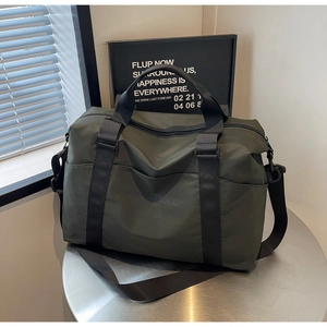 Close-up of olive green nylon travel bag with embossed brand logo on the front pocket