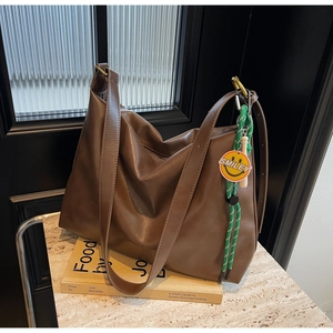 Sac hobo en cuir souple marron avec large bandoulière et pendentif smiley vert décoratif