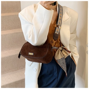Detail of dark brown suede cylinder bag with vintage strap and silk scarf accessory