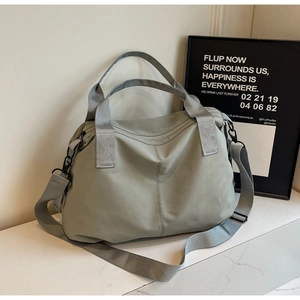 Detailed side view of water-resistant nylon tote with metal hooks on marble