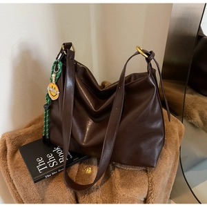 Détails du sac cabas marron foncé en simili cuir avec bijou de sac souriant