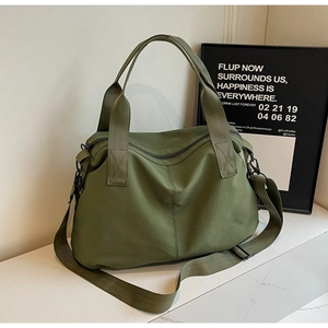 Detail of olive green tote bag showing reinforced handles and metal buckle hardware
