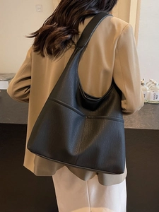 Minimalist black lychee texture tote bag for women shown from a side-view on shoulder