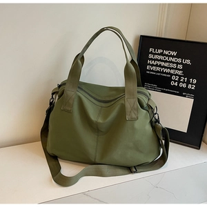 Macro detail of large olive green nylon tote bag with durable handles and adjustable strap