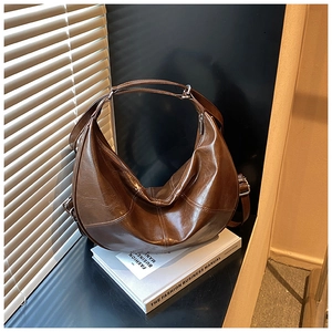 Detailed close-up of a vintage brown leather hobo bag with distinctive double stitching
