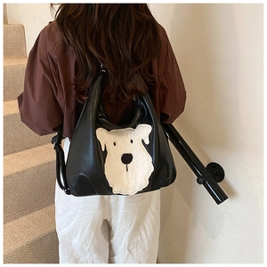 Detail of cute white plush dog patch on a black PU leather backpack for women