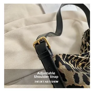 Close-up of leopard print bucket bag with adjustable black strap and gold buckle