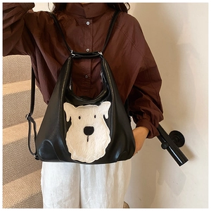 Detail of the black leather bag with a fluffy white dog patch on a minimalist staircase