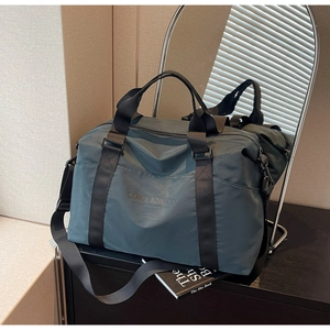 Close-up of teal travel duffel bag with durable nylon texture and branded lettering