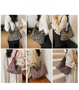 Detail view of large leopard print tote bags in yellow and red on models in a studio setting