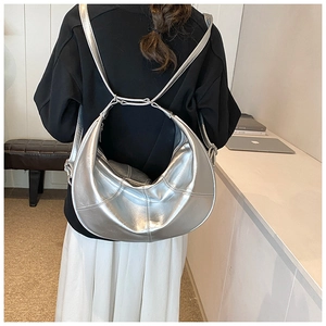 Detail of silver metallic hobo backpack with pleated seams and adjustable straps