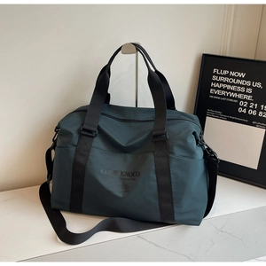 Detail view of large dark teal travel bag with dual handles and wide shoulder strap