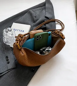 Interior view of brown lychee leather dumpling bag showing spacious storage for accessories