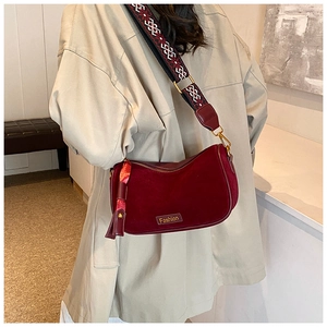 Detail of burgundy velvet crossbody bag with a wide ethnic style patterned strap
