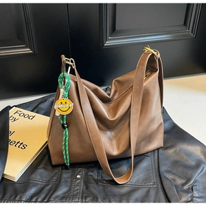Vue détaillée du sac hobo en cuir marron avec pendentif tressé vert et smiley