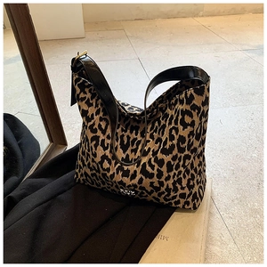 Detailed shot of leopard print hobo bag with black leather strap and gold hardware