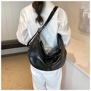 Glossy black crescent moon bag shown on model for stylish size and fit perspective