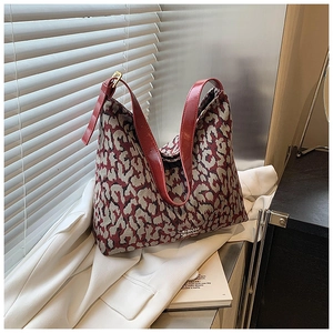 Detail of red leopard print bucket bag with high-quality leather strap and metal buckle