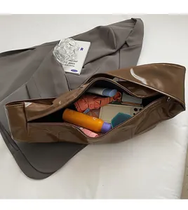 Detail of spacious interior in brown patent leather tote bag with daily essentials